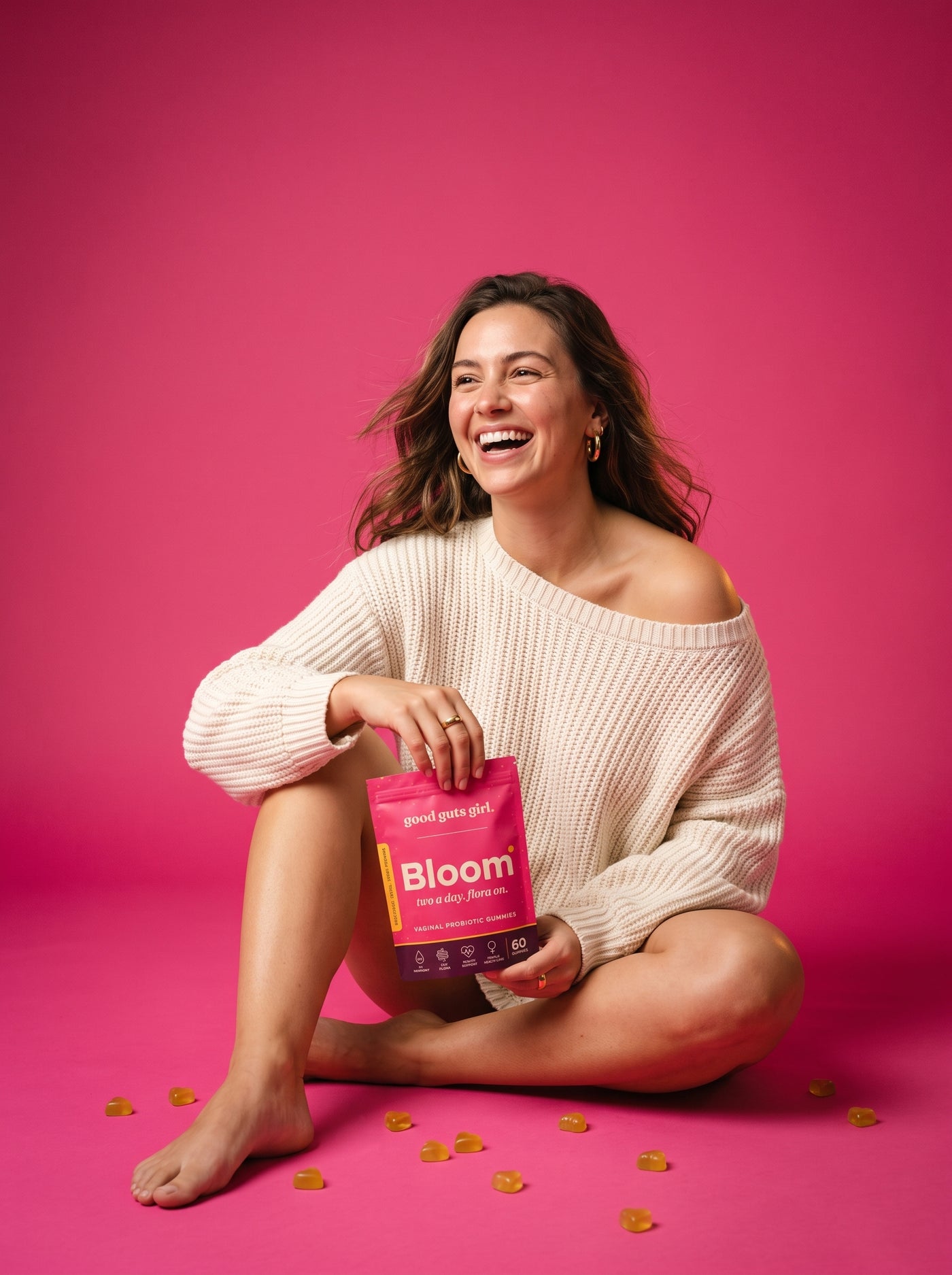 en kvinna som skrattar på ett rosa studiogolv med bloom-påsen — orädd glädje